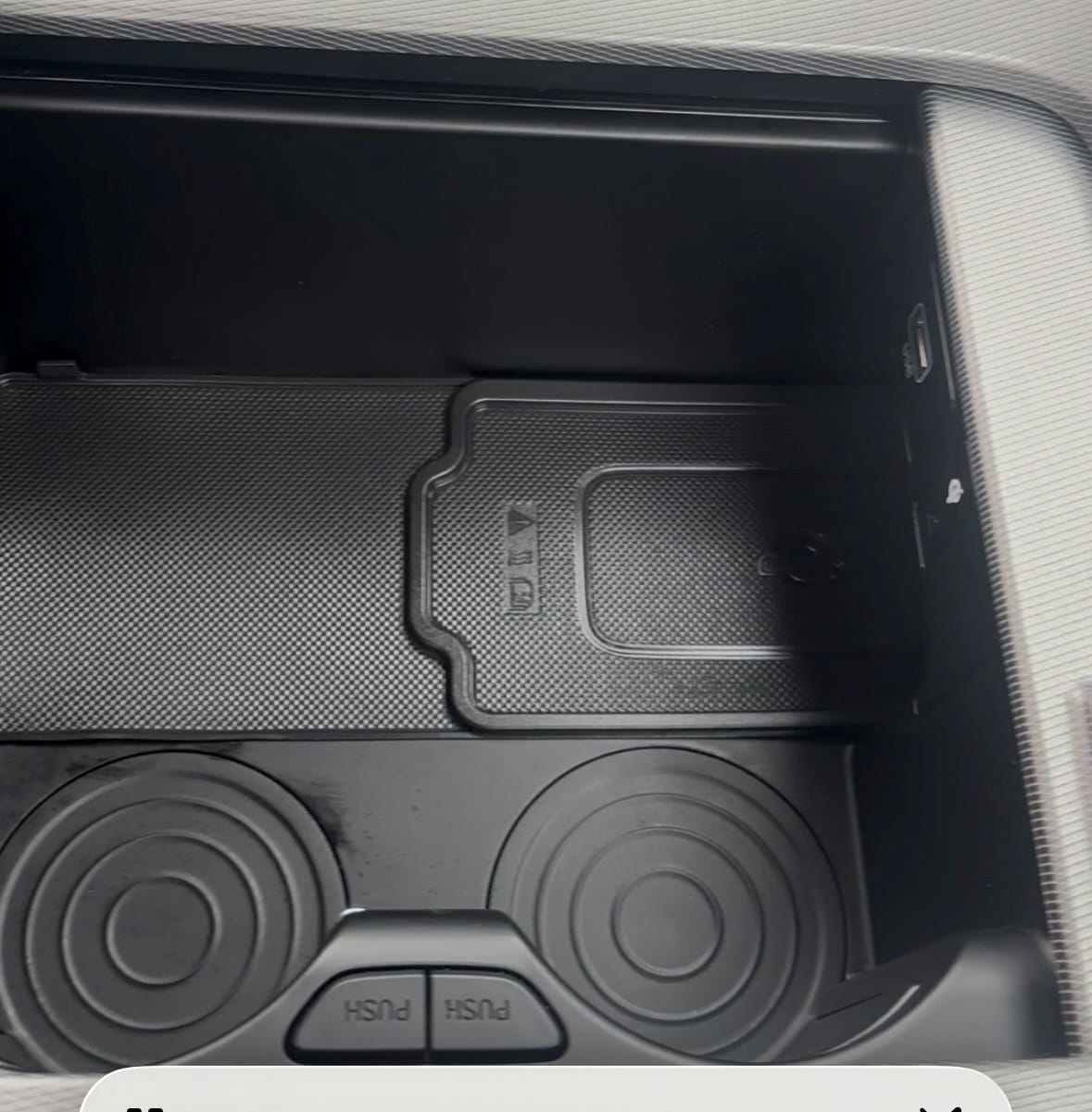 Vehicle center console and cup holders after interior detailing, showing a clean and restored surface.